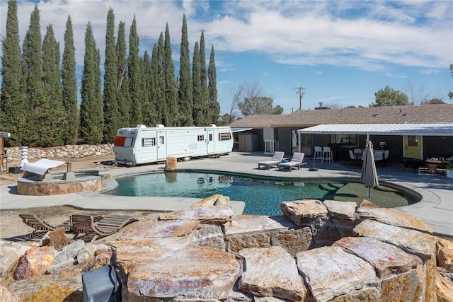 outdoor pool featuring an outdoor fire pit and a patio