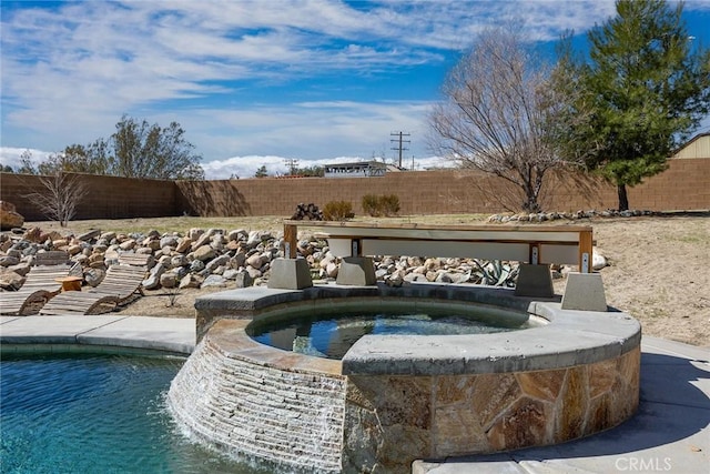 view of swimming pool featuring a fenced backyard and an in ground hot tub