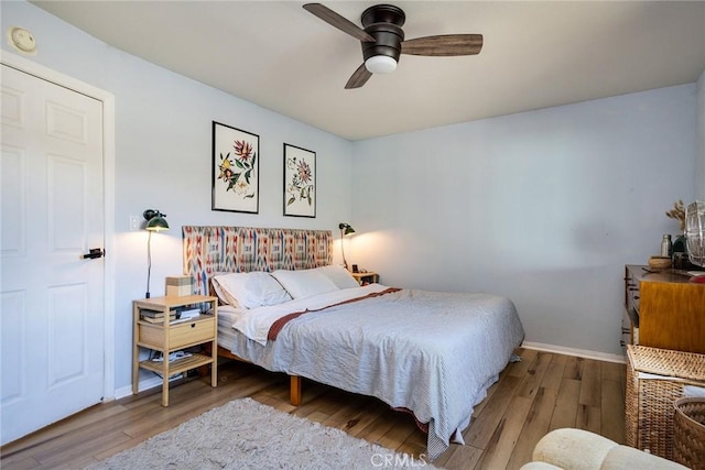 bedroom featuring ceiling fan, baseboards, and wood finished floors