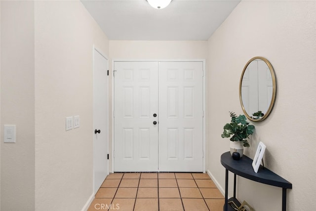 entryway featuring light tile patterned flooring and baseboards