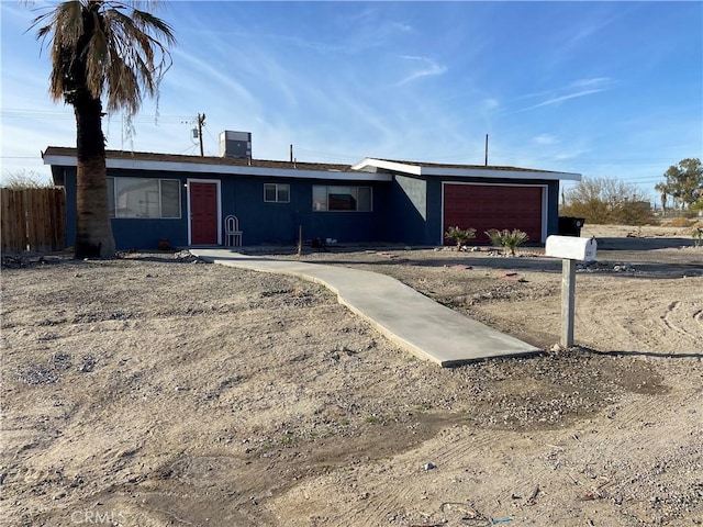 view of front of house with a garage, fence, and central AC