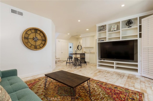 living room with light wood-type flooring, recessed lighting, and visible vents