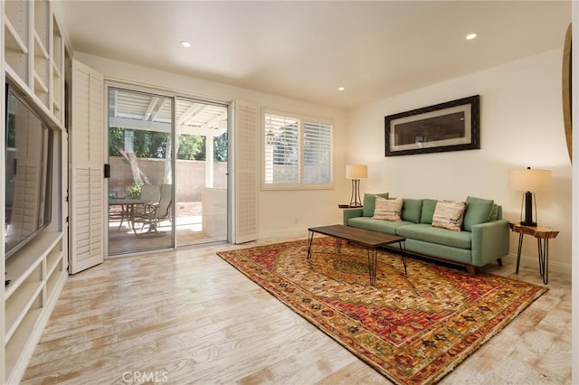 living room featuring light wood finished floors, baseboards, and recessed lighting