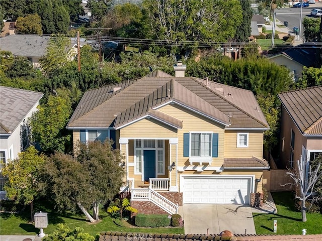 view of front of property featuring a garage, a chimney, concrete driveway, and a tiled roof