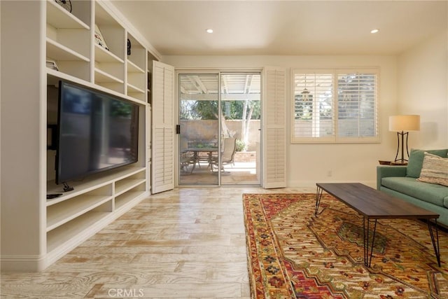 living room with baseboards, wood finished floors, and recessed lighting