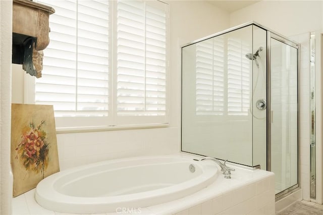 full bath with a stall shower and a garden tub