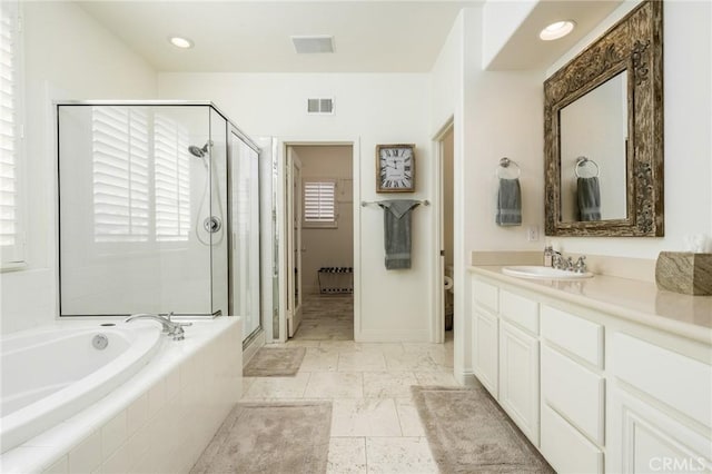 bathroom featuring vanity, a stall shower, a garden tub, and visible vents