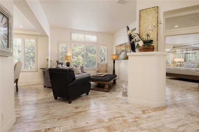 living area featuring plenty of natural light, baseboards, and wood finished floors