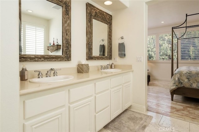 ensuite bathroom featuring a sink, connected bathroom, and a healthy amount of sunlight