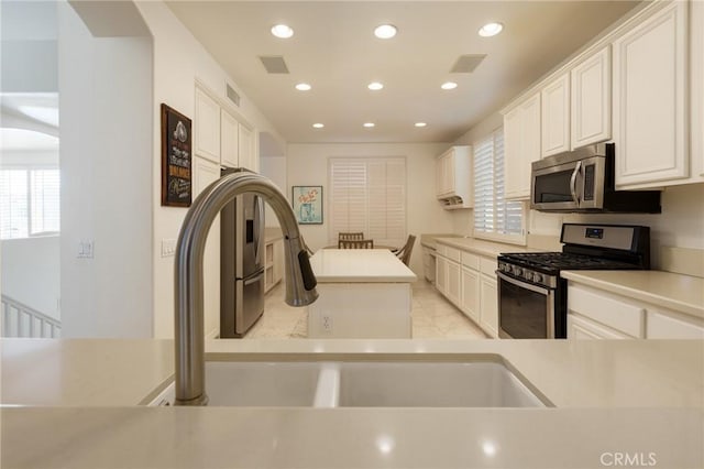 kitchen featuring appliances with stainless steel finishes, visible vents, and white cabinetry