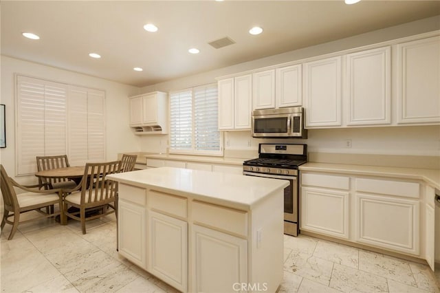 kitchen featuring recessed lighting, stainless steel appliances, visible vents, marble finish floor, and a center island