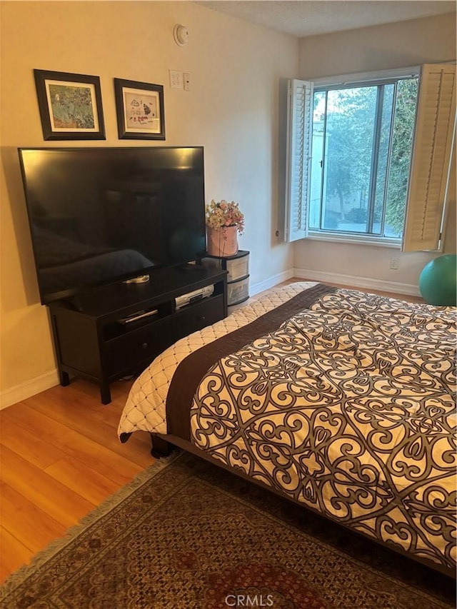 bedroom with baseboards and wood finished floors