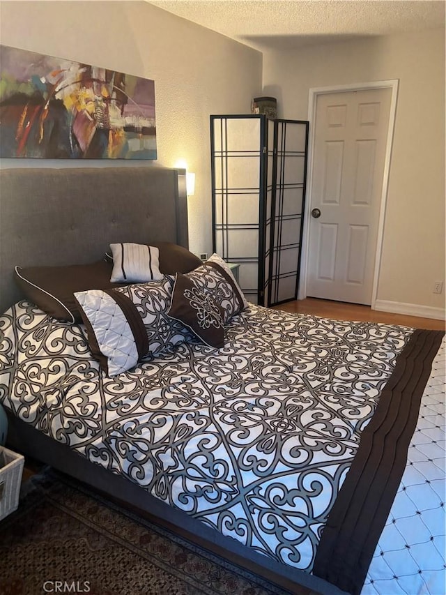 bedroom featuring a textured ceiling and baseboards