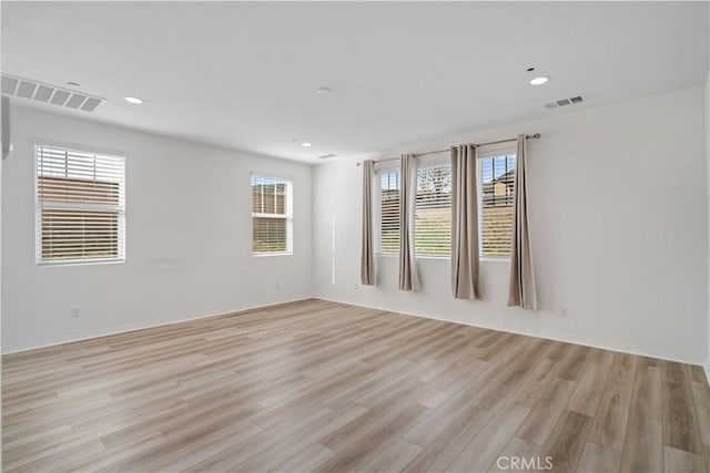 spare room with visible vents, plenty of natural light, and light wood-style flooring