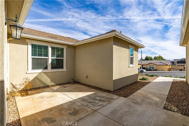 view of side of property with a patio area and stucco siding