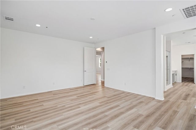 spare room featuring light wood finished floors, visible vents, and recessed lighting