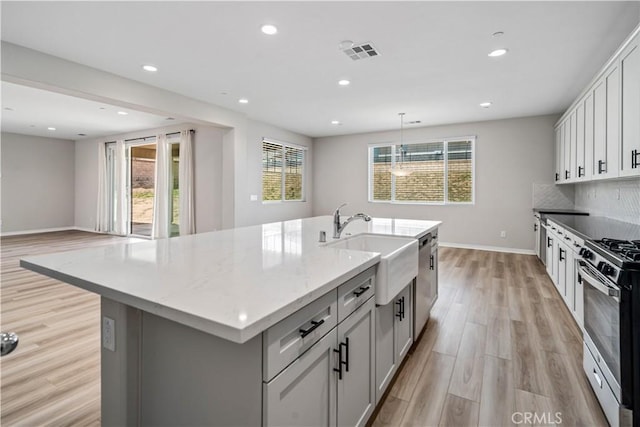 kitchen featuring stainless steel appliances, a healthy amount of sunlight, visible vents, and light wood-style flooring