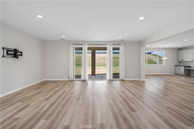 unfurnished living room featuring light wood finished floors, plenty of natural light, and recessed lighting