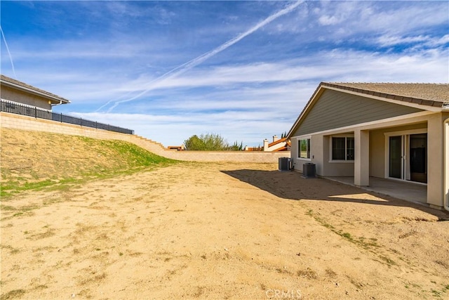 view of yard featuring central AC unit and fence