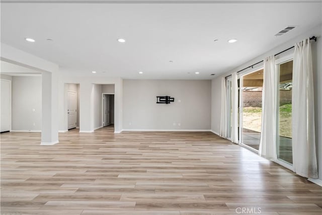 spare room with recessed lighting, visible vents, light wood-style flooring, and baseboards