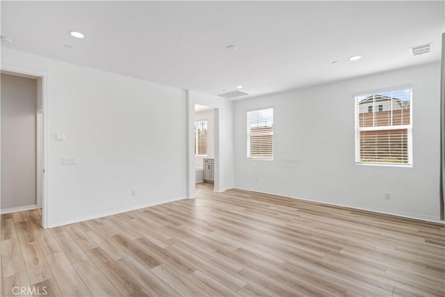 spare room with recessed lighting, visible vents, light wood-style flooring, and baseboards