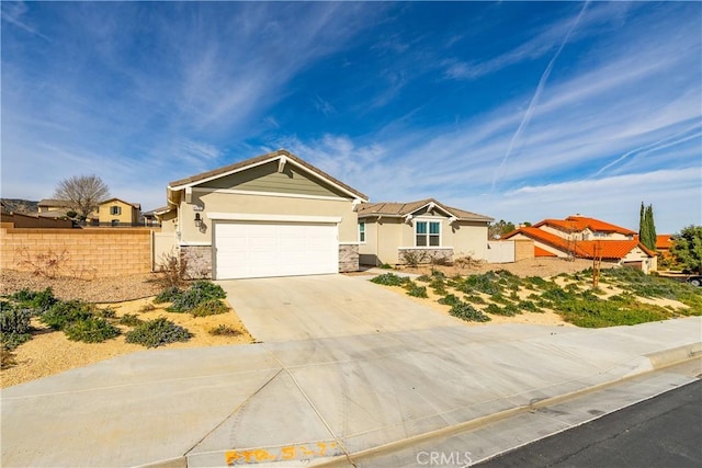 ranch-style house with driveway, stone siding, an attached garage, fence, and stucco siding