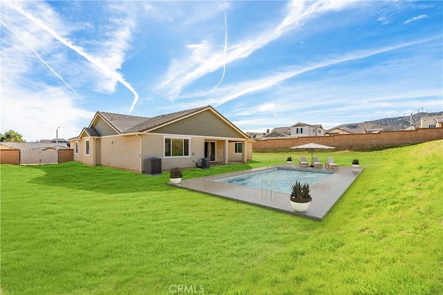 rear view of house with a fenced in pool, a patio, fence, a yard, and central AC