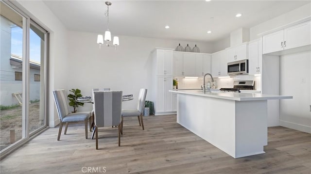 366 S Halcyon Rd, Arroyo Grande, CA 93420 - kitchen featuring stainless steel microwave, stove, a chandelier, decorative backsplash, and white cabinetry