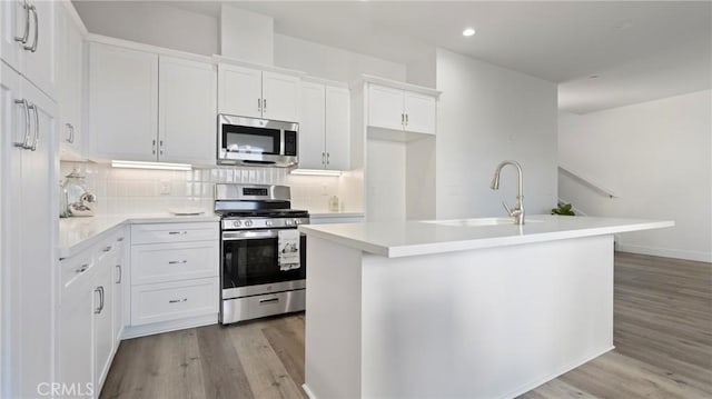 366 S Halcyon Rd, Arroyo Grande, CA 93420 - kitchen featuring appliances with stainless steel finishes, light wood-type flooring, white cabinetry, tasteful backsplash, and recessed lighting
