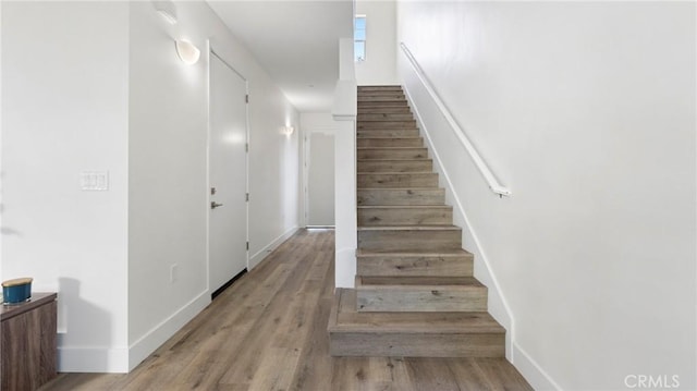 stairs with baseboards and wood finished floors