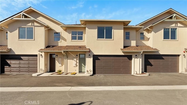 multi unit property featuring an attached garage and stucco siding