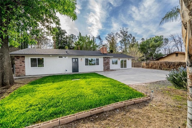 ranch-style house featuring a chimney, fence, a patio area, a front lawn, and stucco siding