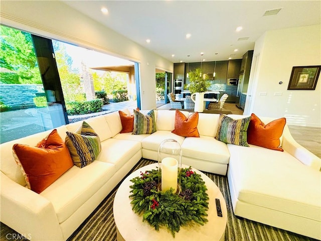 living area featuring light wood-type flooring, visible vents, and recessed lighting