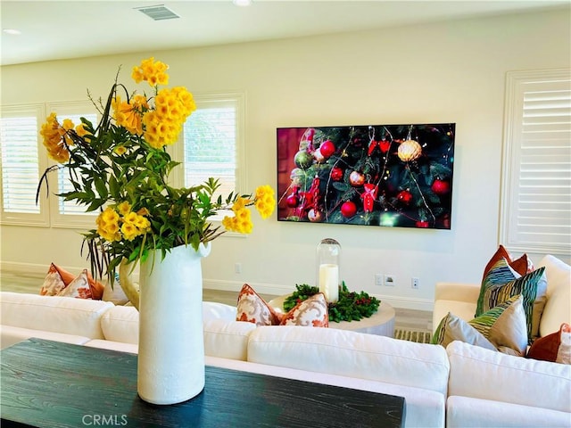 living room featuring baseboards, visible vents, and recessed lighting