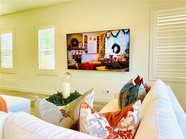 living area with baseboards and wood finished floors