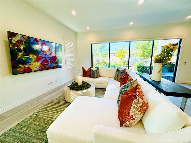 living room with recessed lighting, baseboards, and wood finished floors