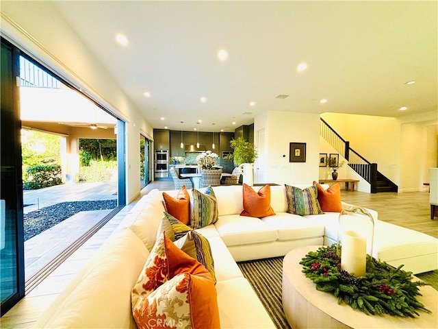 living room with stairs, light wood-type flooring, and recessed lighting