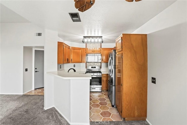 2568 Avenida Del Vis Unit 203, Corona, CA 92882 - kitchen featuring appliances with stainless steel finishes, a peninsula, light countertops, a sink, and brown cabinetry