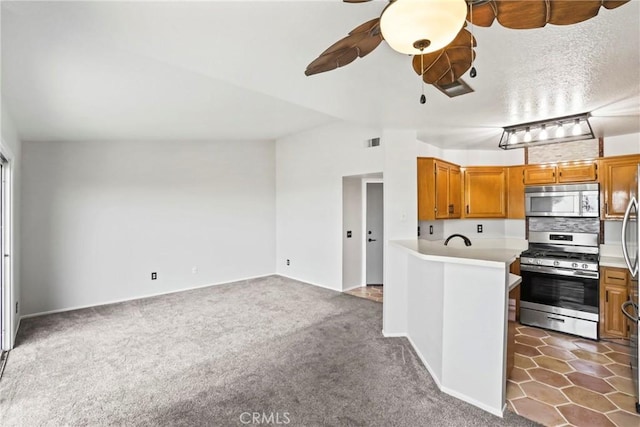 2568 Avenida Del Vis Unit 203, Corona, CA 92882 - kitchen with appliances with stainless steel finishes, a ceiling fan, light countertops, and brown cabinets