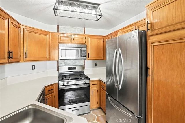 2568 Avenida Del Vis Unit 203, Corona, CA 92882 - kitchen with appliances with stainless steel finishes, light countertops, brown cabinets, and light tile patterned floors