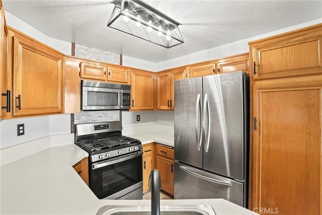 2568 Avenida Del Vis Unit 203, Corona, CA 92882 - kitchen featuring stainless steel appliances, light countertops, a textured ceiling, a sink, and brown cabinetry