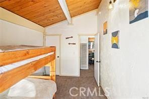 bedroom featuring vaulted ceiling with beams, wood ceiling, and carpet floors