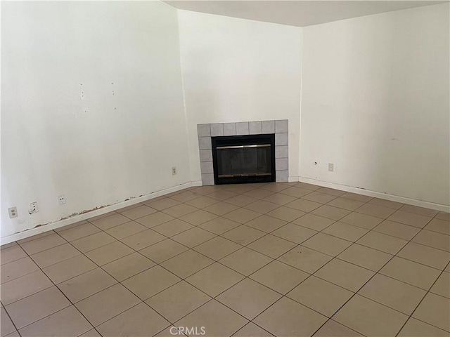 unfurnished living room featuring a fireplace and baseboards