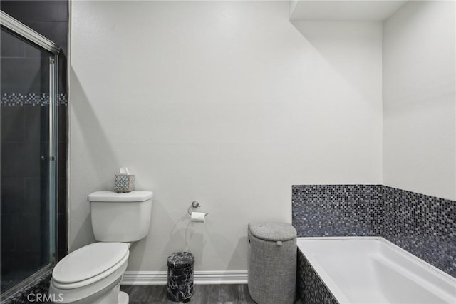 bathroom featuring wood finished floors, a shower stall, toilet, and baseboards