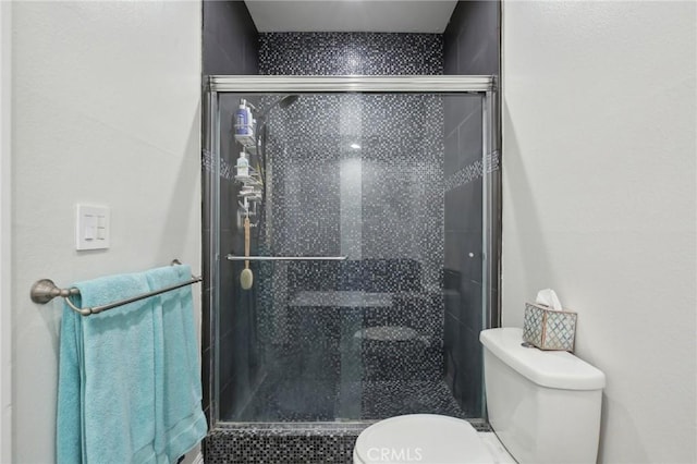 full bath featuring a shower stall and toilet