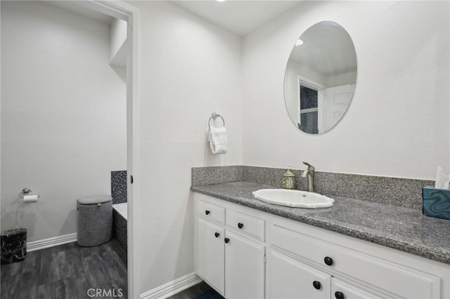 bathroom featuring wood finished floors, vanity, and baseboards