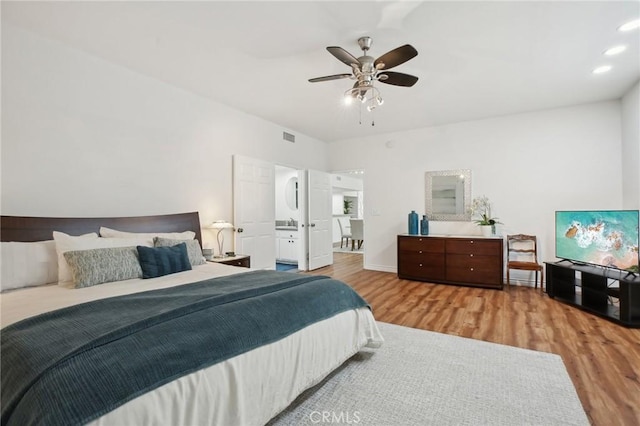 bedroom featuring ceiling fan, recessed lighting, wood finished floors, visible vents, and baseboards