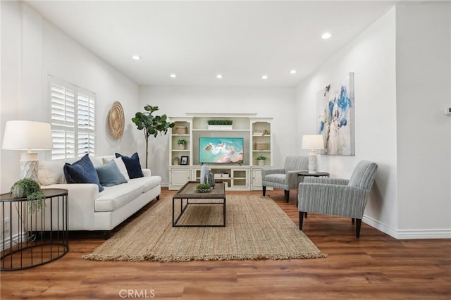 living room featuring baseboards, wood finished floors, and recessed lighting