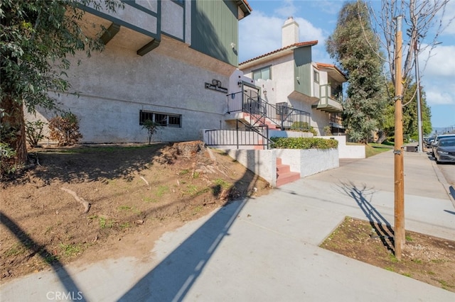 view of property exterior with a chimney and stucco siding