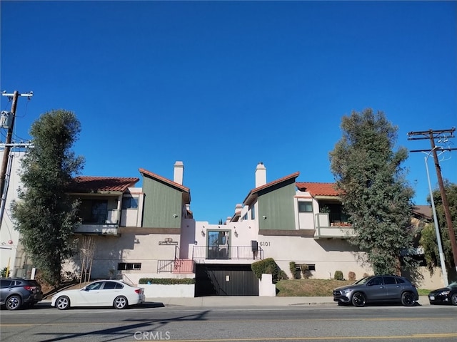 exterior space with a tile roof and stucco siding